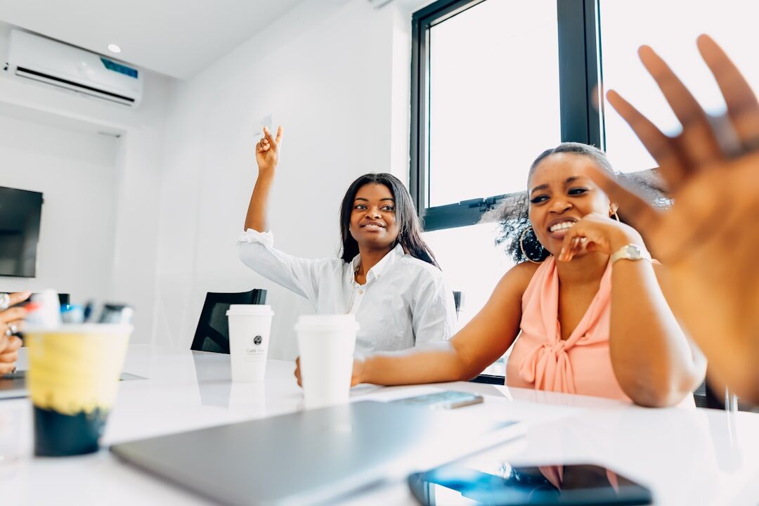 Group of diverse coworkers celebrating with raised hands in a bright office